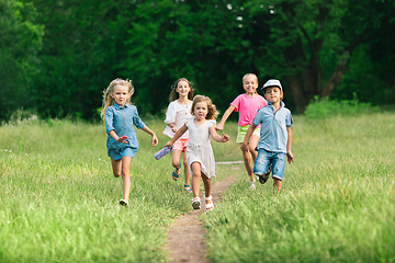 Image showing Kids, children running on meadow in summer\'s sunlight