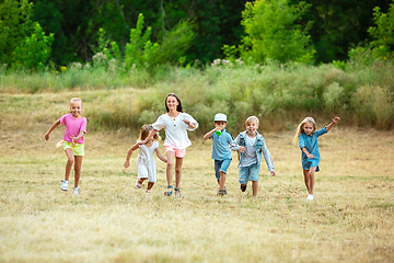 Image showing Kids, children running on meadow in summer\'s sunlight