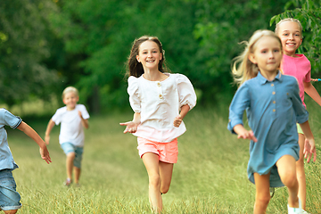 Image showing Kids, children running on meadow in summer\'s sunlight