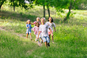 Image showing Kids, children running on meadow in summer\'s sunlight