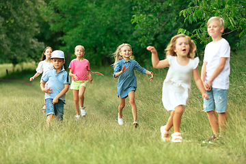 Image showing Kids, children running on meadow in summer\'s sunlight