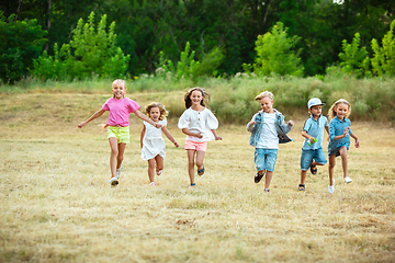 Image showing Kids, children running on meadow in summer\'s sunlight