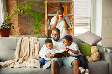 Image showing Young african family during quarantine, insulation spending time together at home