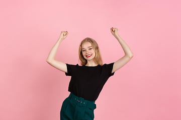 Image showing Young emotional woman on pink studio background. Human emotions, facial expression concept.