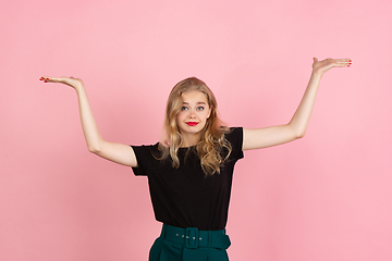 Image showing Young emotional woman on pink studio background. Human emotions, facial expression concept.