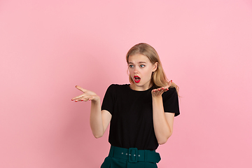 Image showing Young emotional woman on pink studio background. Human emotions, facial expression concept.