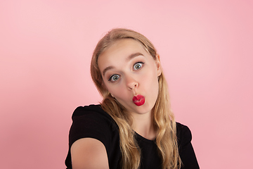 Image showing Young emotional woman on pink studio background. Human emotions, facial expression concept.