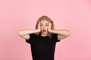 Image showing Young emotional woman on pink studio background. Human emotions, facial expression concept.