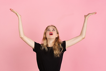 Image showing Young emotional woman on pink studio background. Human emotions, facial expression concept.