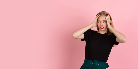 Image showing Young emotional woman on pink studio background. Human emotions, facial expression concept.