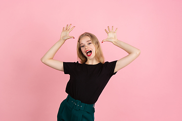 Image showing Young emotional woman on pink studio background. Human emotions, facial expression concept.