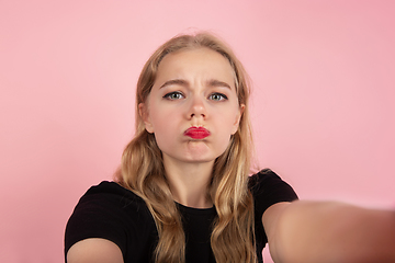 Image showing Young emotional woman on pink studio background. Human emotions, facial expression concept.