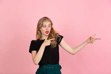 Image showing Young emotional woman on pink studio background. Human emotions, facial expression concept.