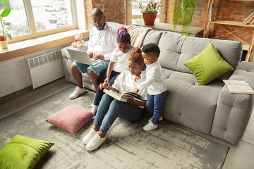 Image showing Young african family during quarantine, insulation spending time together at home