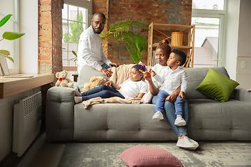 Image showing Young african family during quarantine, insulation spending time together at home