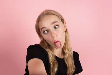 Image showing Young emotional woman on pink studio background. Human emotions, facial expression concept.