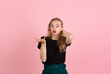 Image showing Young emotional woman on pink studio background. Human emotions, facial expression concept.