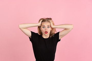 Image showing Young emotional woman on pink studio background. Human emotions, facial expression concept.