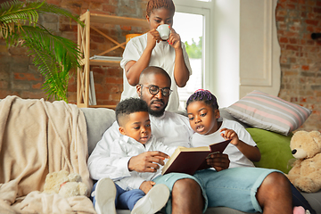 Image showing Young african family during quarantine, insulation spending time together at home