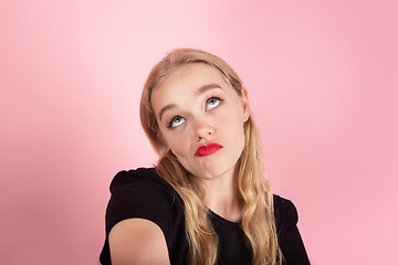 Image showing Young emotional woman on pink studio background. Human emotions, facial expression concept.