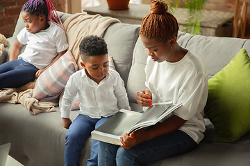 Image showing Young african family during quarantine, insulation spending time together at home