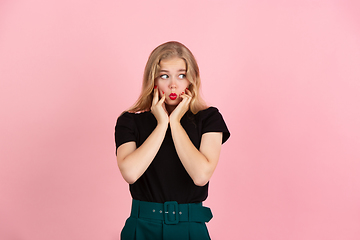 Image showing Young emotional woman on pink studio background. Human emotions, facial expression concept.