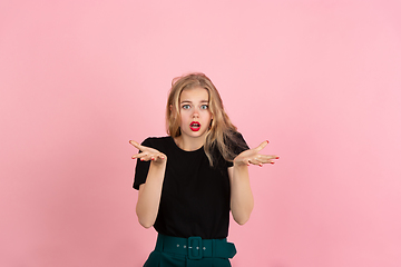 Image showing Young emotional woman on pink studio background. Human emotions, facial expression concept.