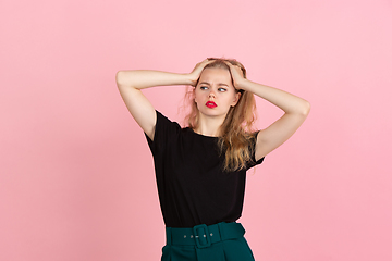 Image showing Young emotional woman on pink studio background. Human emotions, facial expression concept.