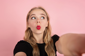 Image showing Young emotional woman on pink studio background. Human emotions, facial expression concept.