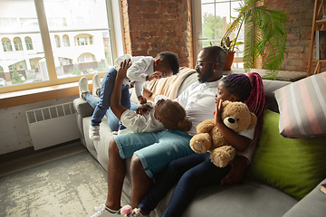 Image showing Young african family during quarantine, insulation spending time together at home