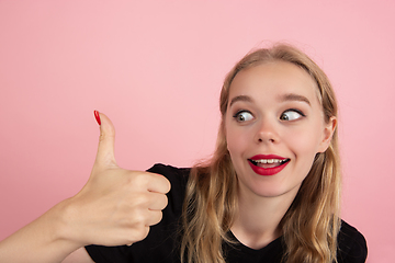 Image showing Young emotional woman on pink studio background. Human emotions, facial expression concept.