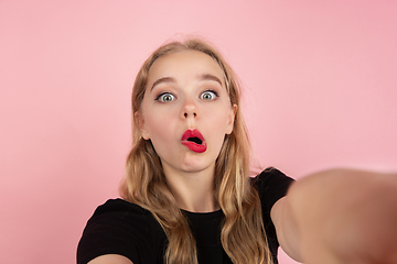 Image showing Young emotional woman on pink studio background. Human emotions, facial expression concept.