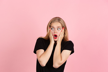 Image showing Young emotional woman on pink studio background. Human emotions, facial expression concept.