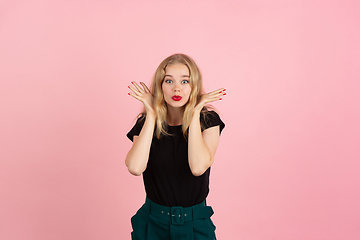 Image showing Young emotional woman on pink studio background. Human emotions, facial expression concept.