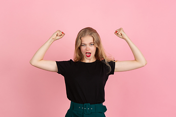 Image showing Young emotional woman on pink studio background. Human emotions, facial expression concept.