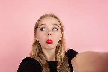 Image showing Young emotional woman on pink studio background. Human emotions, facial expression concept.