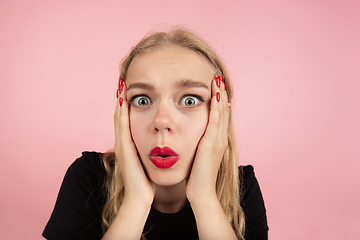 Image showing Young emotional woman on pink studio background. Human emotions, facial expression concept.