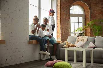 Image showing Young african family during quarantine, insulation spending time together at home