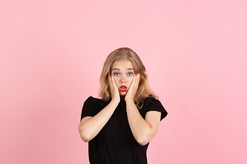 Image showing Young emotional woman on pink studio background. Human emotions, facial expression concept.