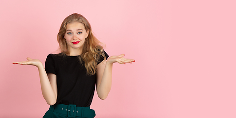 Image showing Young emotional woman on pink studio background. Human emotions, facial expression concept.