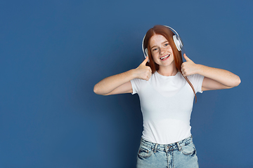 Image showing Caucasian young girl\'s portrait isolated on blue studio background. Beautiful female model. Concept of human emotions, facial expression, sales, ad, youth culture.