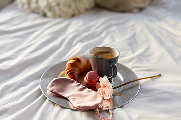 Image showing croissant, coffee and eye sleeping mask in bed