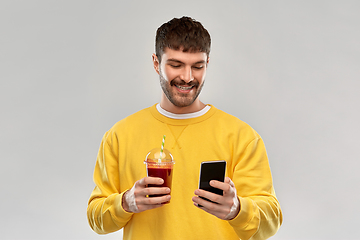 Image showing happy man with smartphone and tomato juice