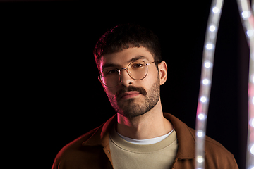 Image showing man in glasses over neon lights at nightclub