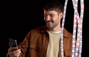 Image showing happy smiling young man with smartphone