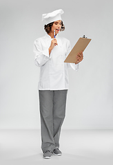 Image showing smiling female chef in toque with clipboard