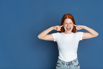 Image showing Caucasian young girl\'s portrait isolated on blue studio background. Beautiful female model. Concept of human emotions, facial expression, sales, ad, youth culture.