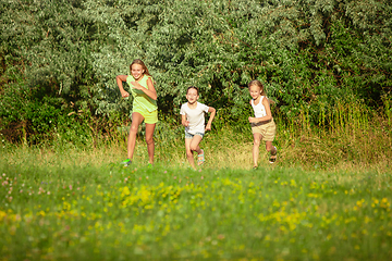 Image showing Kids, children running on meadow in summer\'s sunlight