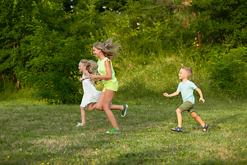 Image showing Kids, children running on meadow in summer\'s sunlight