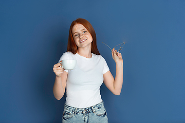 Image showing Caucasian young girl\'s portrait isolated on blue studio background. Beautiful female model. Concept of human emotions, facial expression, sales, ad, youth culture.